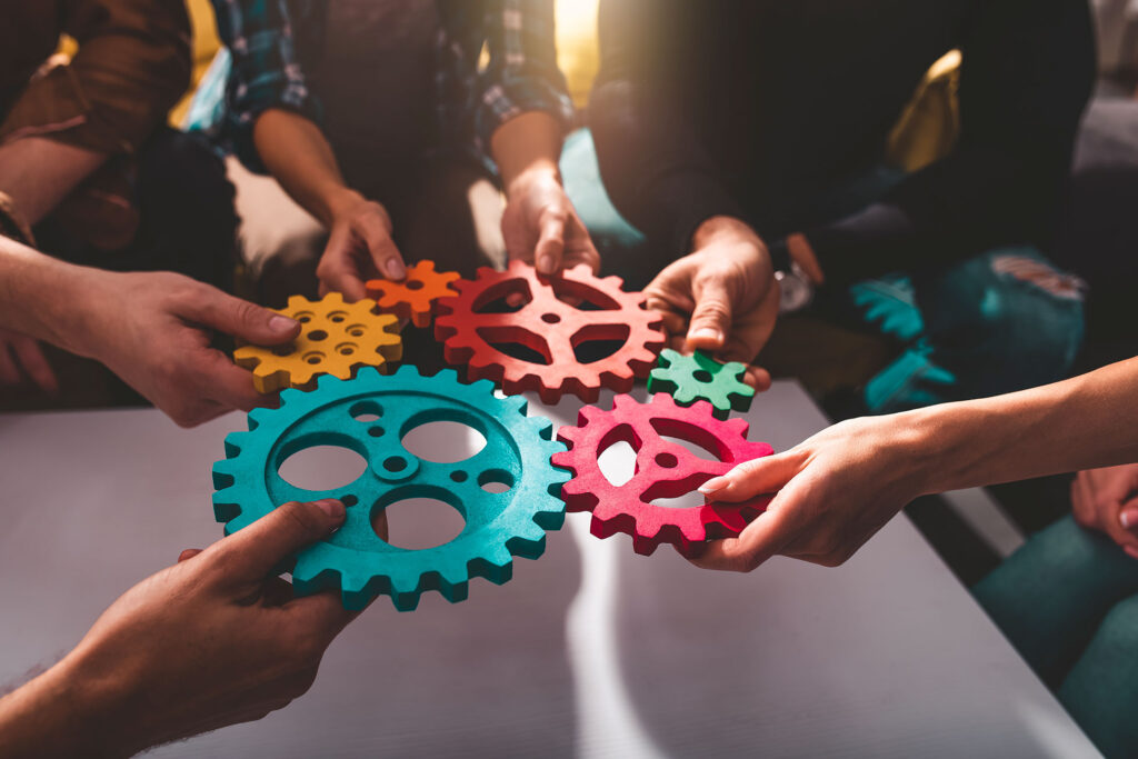 Lavoro di squadra: delle persone collaborano e combinano ingranaggi